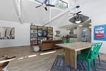 A room with a table, chairs and a ceiling fan.
